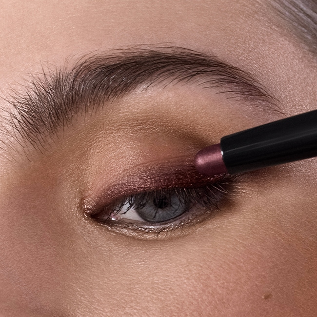 Close up of model eye showcasing defined brows and a natural, shimmery eye look